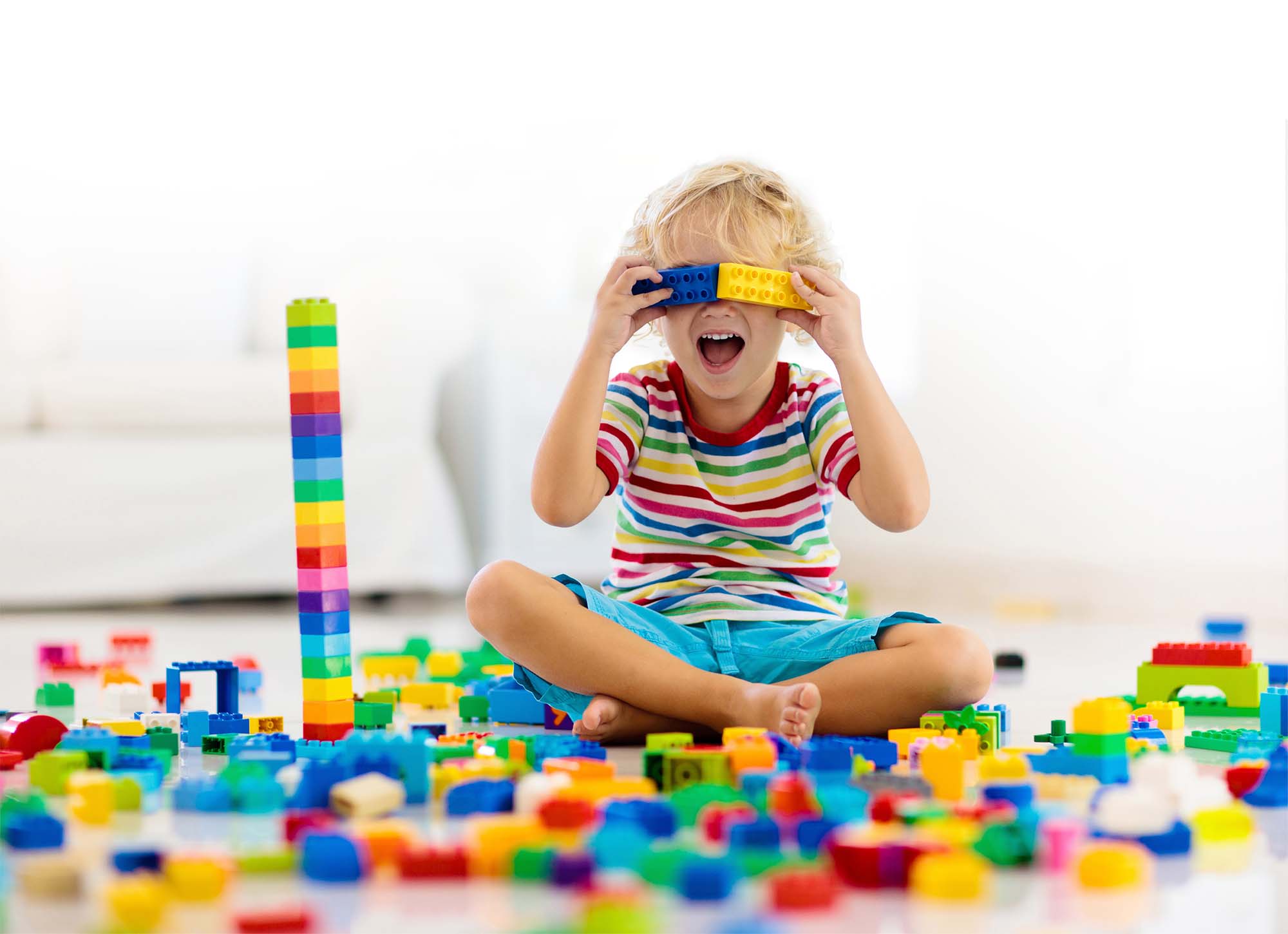 Kind spielt mit Bausteinen. Professionelle Kinderbetreuung finden über manny+nanny.