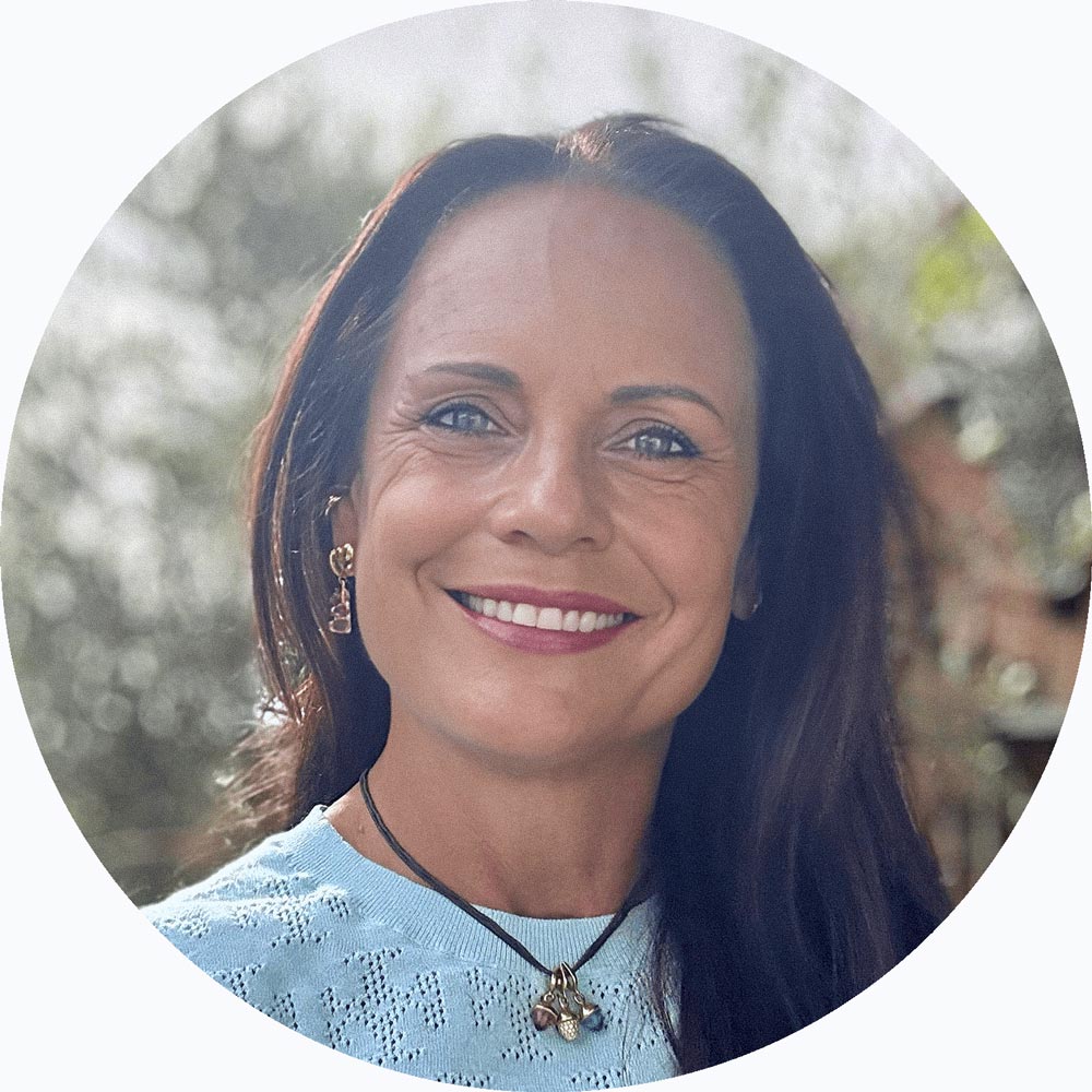 Porträt einer Frau mit warmem Lächeln. Empathische, professionelle Kinderbetreuung.