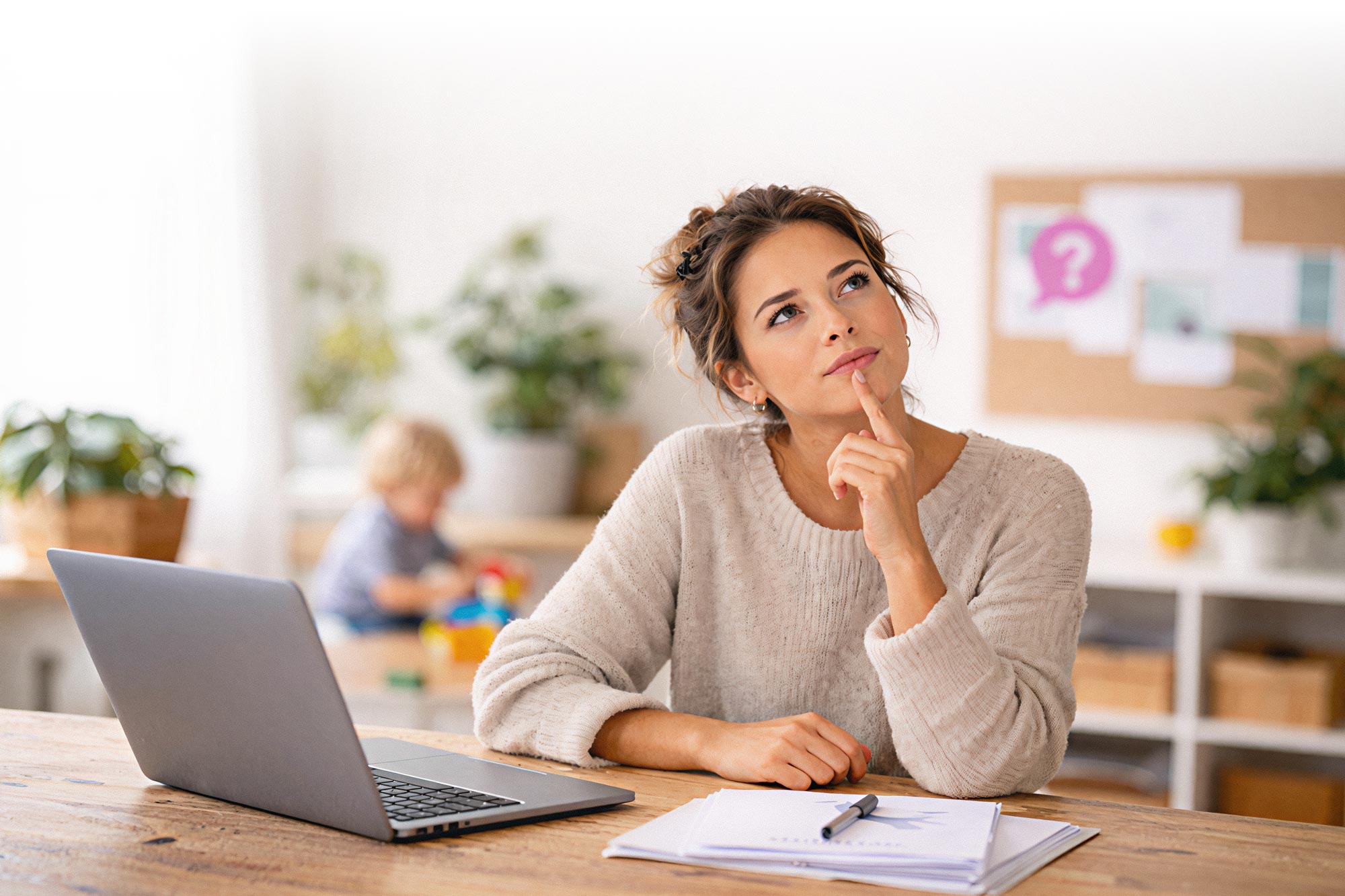 Nachdenkliche Mutter am Laptop. Fragen zur Kinderbetreuung bei manny+nanny deutschlandweit.