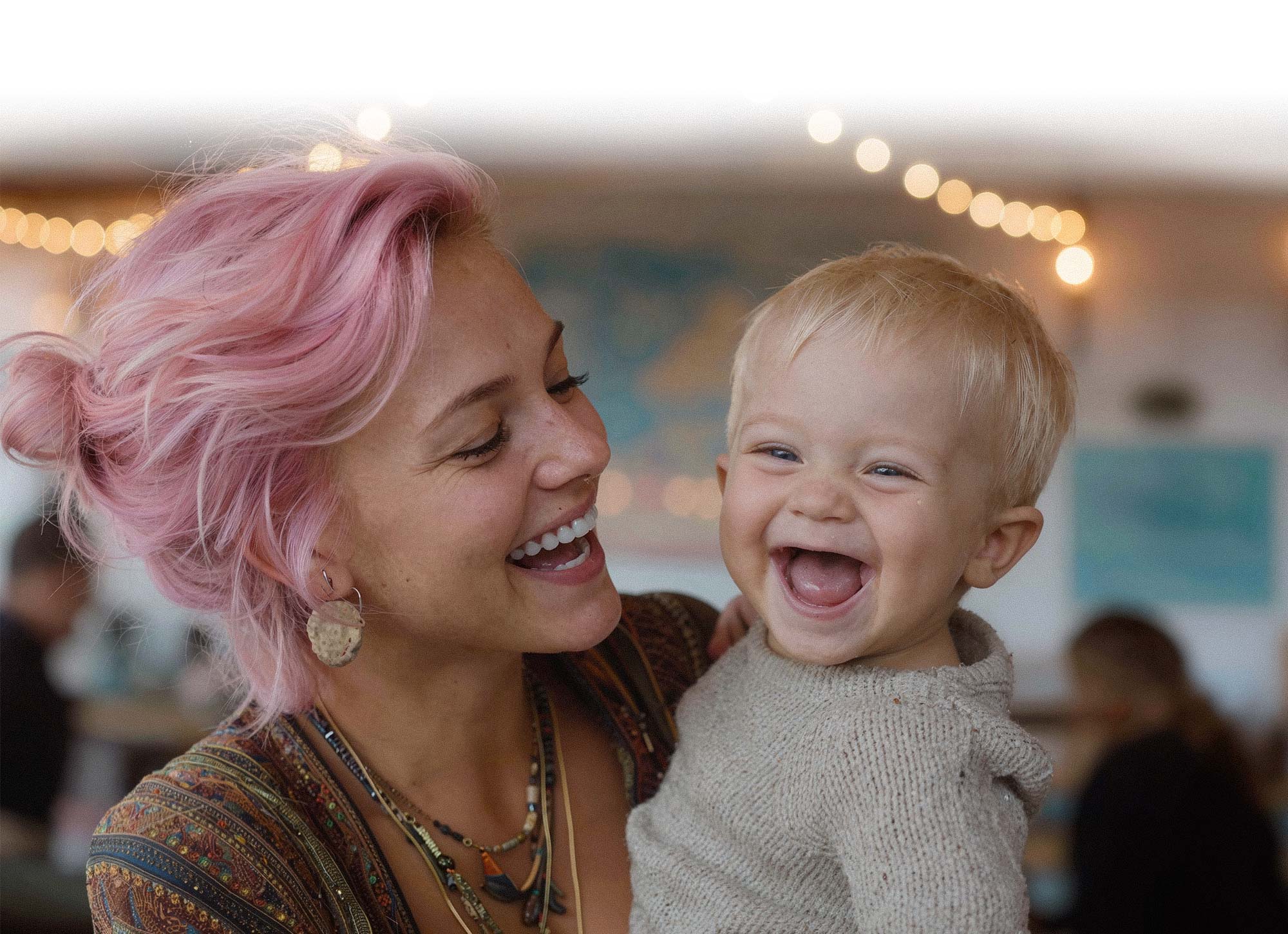 Babysitterin mit lachendem Kleinkind. Professionelle Kinderbetreuung deutschlandweit in allen Bundesländern.