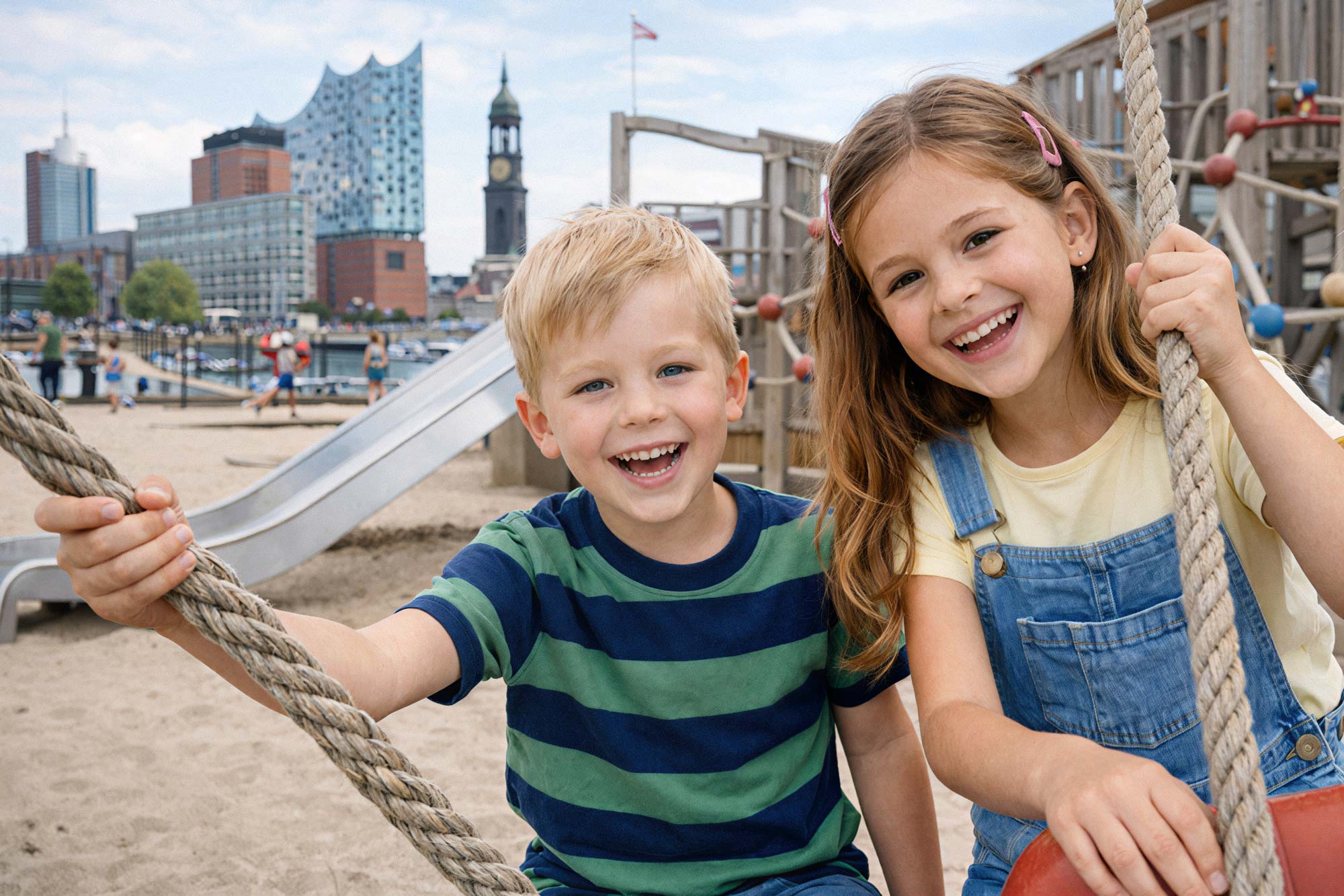 Zwei lachende Kinder an der Alster in Hamburg. Babysitter und Kinderbetreuung in Hamburg.